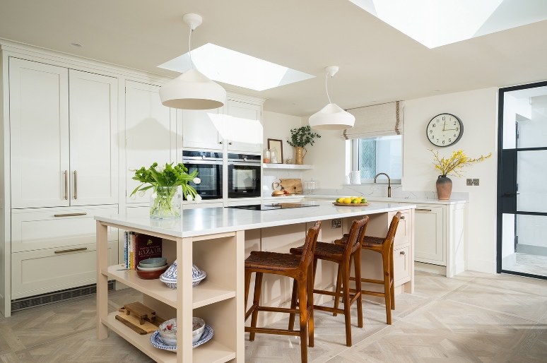 Cream kitchen with island and leather bar stools on parquet-panel porcelain floor