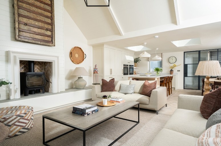 Open-plan living room with stove and vaulted ceiling