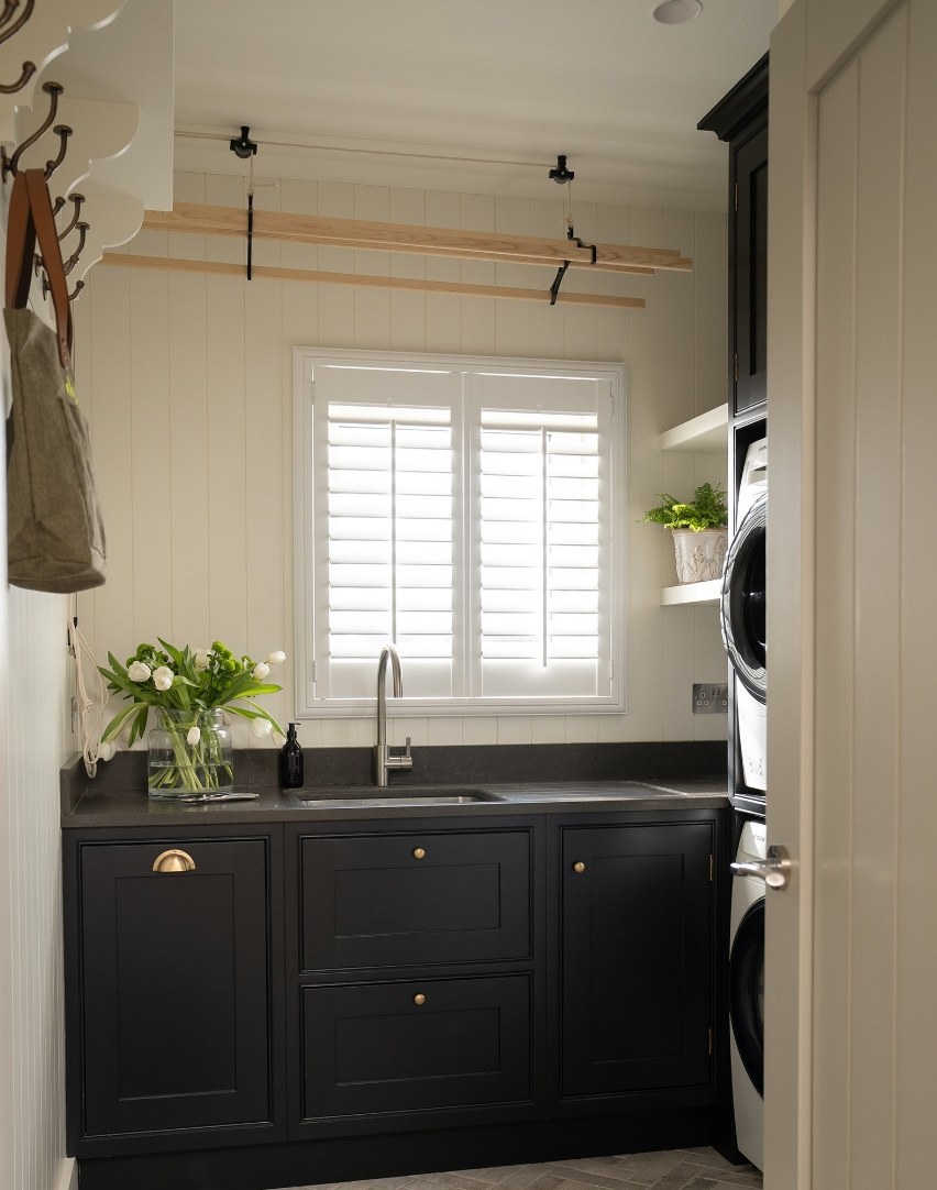 Utility room with dark cabinetry and herringbone brick tile floor